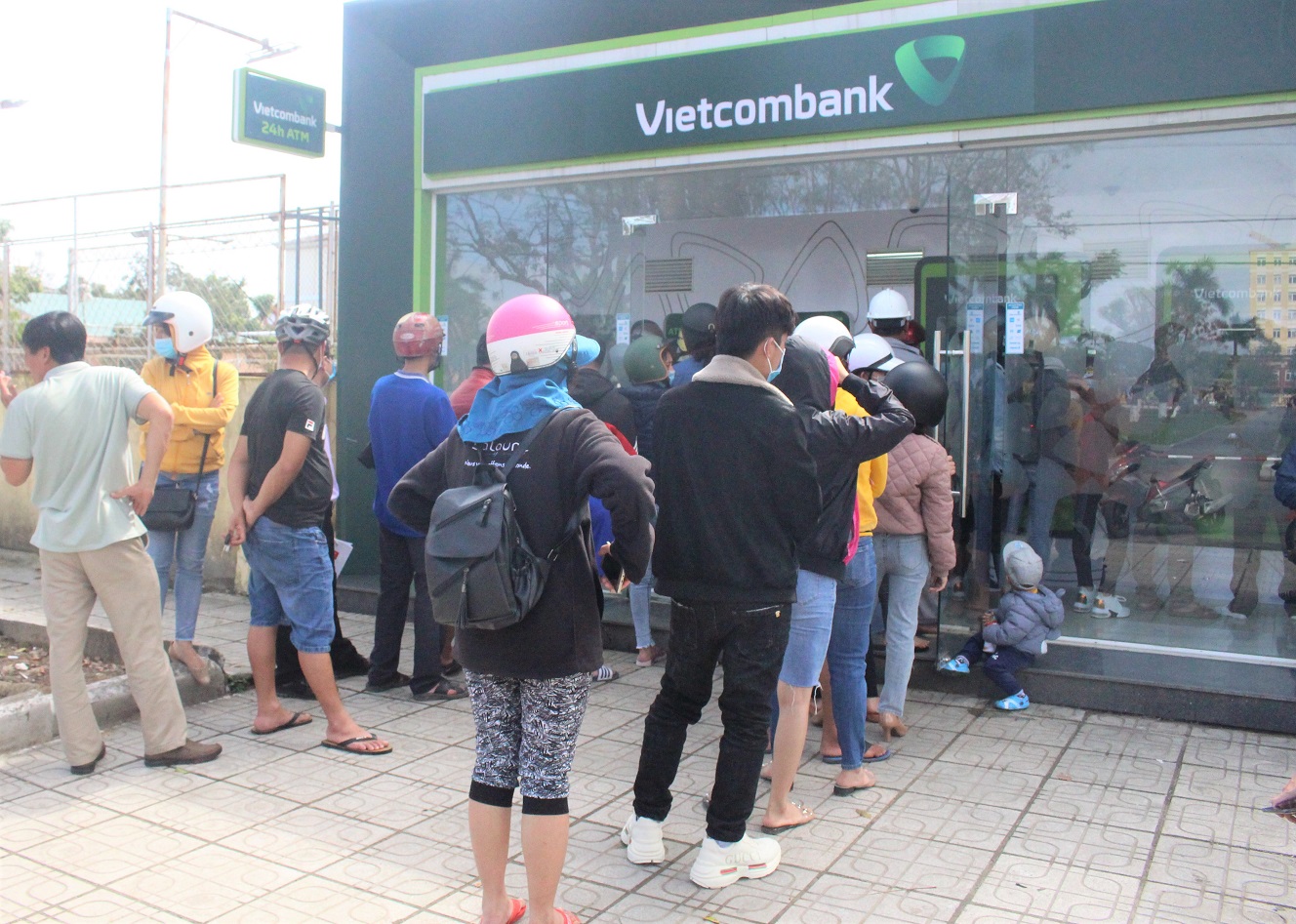 Nhiều khách hàng ở Quảng Nam xếp hàng chờ đến lượt mình vào rút tiền ở cây ATM.