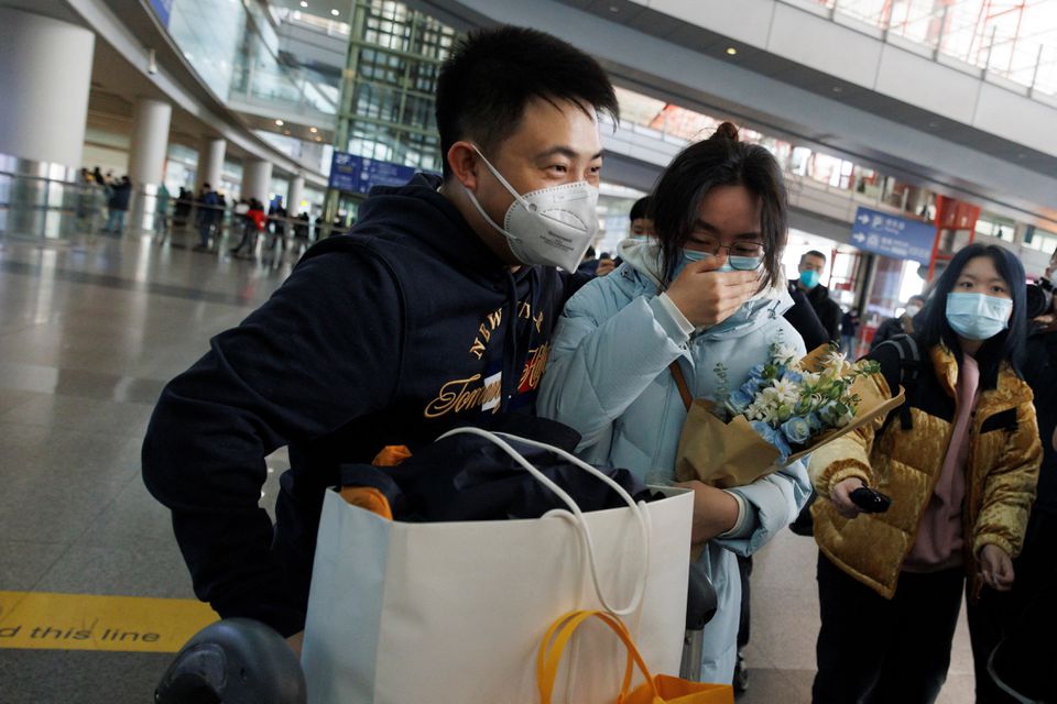 Mọi người &ocirc;m nhau tại cổng đến quốc tế ở S&acirc;n bay Quốc tế Thủ đ&ocirc; Bắc Kinh. Ảnh: Reuters.