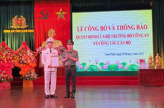 Ủy viên Trung ương Đảng, Thứ trưởng Bộ Công an, Trung tướng Lê Quốc Hùng trao quyết định điều động, bổ nhiệm của Bộ trưởng Bộ Công an cho Đại tá Trần Minh Tiến.
